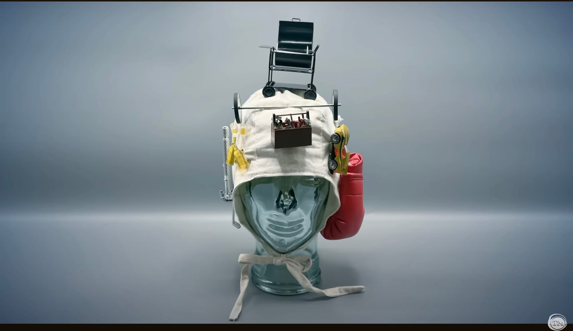 Photo of a white bonnet covered in miniatures: a tiny grill, a tiny barbell, some tiny beers.