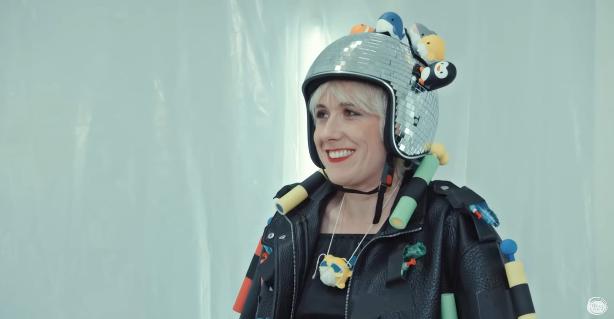 Maisie Adam, grinning and wearing a disco ball helmet.