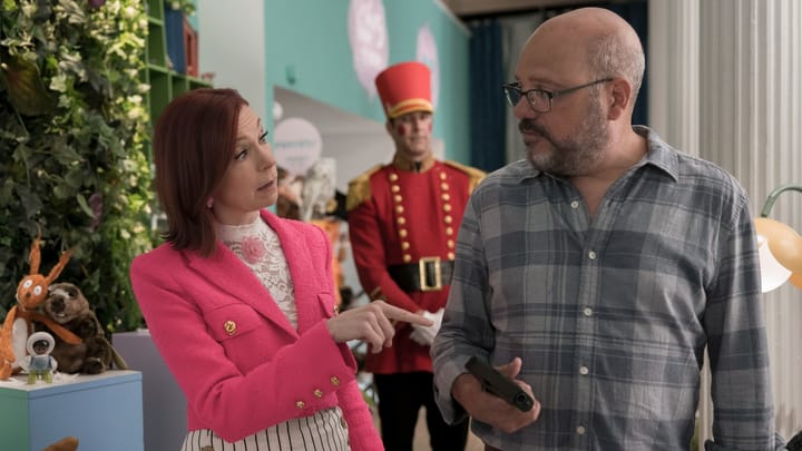 Elsbeth Tascioni points her finger at Nolan Hurst, a man holding a gun in his right hand, while another man dressed like a tin soldier stands behind them.